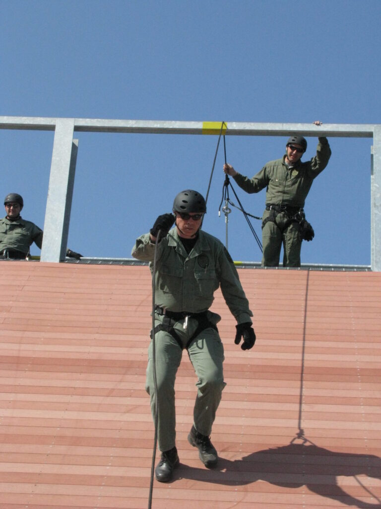Use of force expert and trainer rappelling down a rappeling tower.